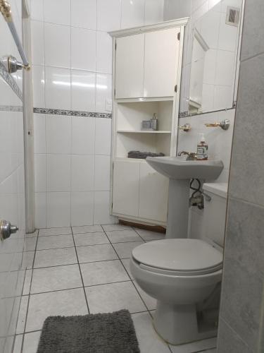 a white bathroom with a toilet and a sink at la casa de la tia Lucita in Ciudad Juárez