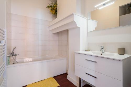 une salle de bain blanche avec un lavabo et une baignoire dans l'établissement Hypercentre Capitole T2 vaste et lumineux, à Toulouse