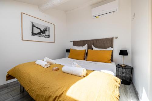 une chambre avec un grand lit avec des oreillers jaunes dans l'établissement MEY T3 - Magnifique LOFT 3 pièces à 50m du vieux port et des plages, à Cannes