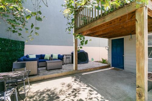 a patio with a blue couch under a wooden pergola at 23 Center St - Sunny Side Down - Downstairs Apartment in Folly Beach