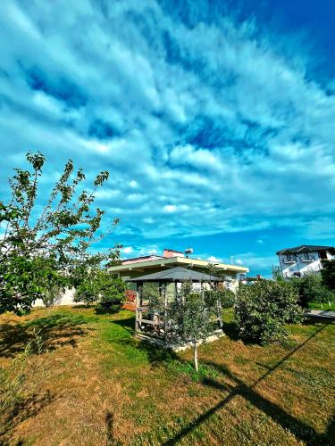 a gazebo in a yard with a cloudy sky at OLIVE Home in Durrës