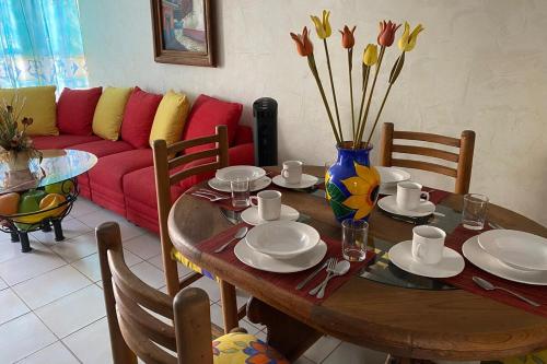 a dining room table with a vase of flowers on it at Viaja y sientete comodo in León