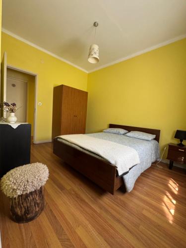 a bedroom with a bed and a yellow wall at Casa dos avós in Maceira