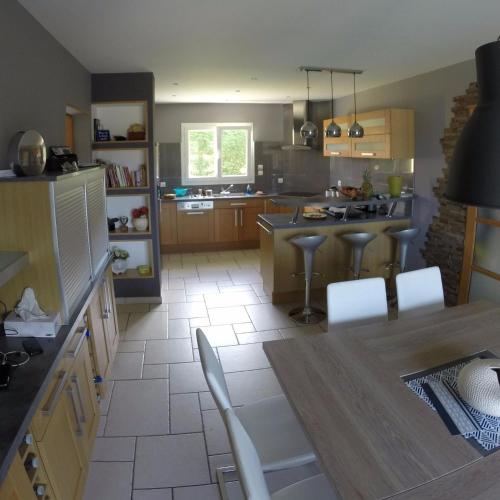 une cuisine avec une table et des chaises dans l'établissement Villa blue Velvet, à Yvré-lʼÉvêque