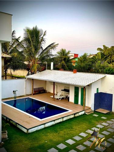 a house with a swimming pool in the yard at Apt Completo e Confortável 300mt Praia de Croa Vermelha in Coroa Vermelha