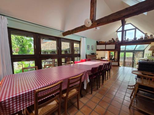 une salle à manger avec une table et des chaises rouges et blanches dans l'établissement Le temps des cigognes, à Barr