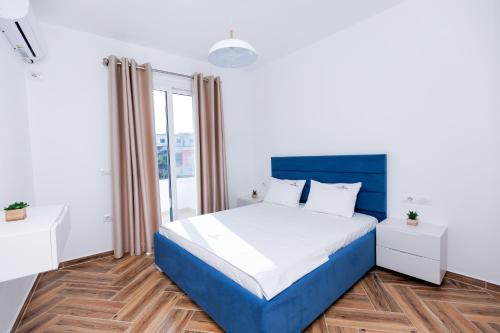 a white and blue bedroom with a blue bed at CAPTAIN'S RESIDENCE in Ksamil