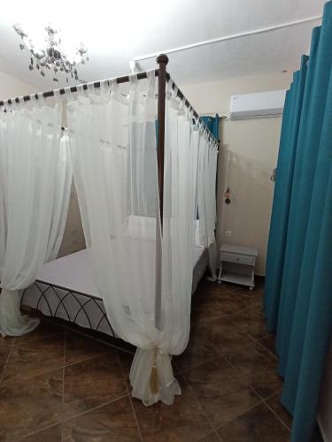 a bedroom with white curtains in a room at Irene' s Paradise in Skopelos Town