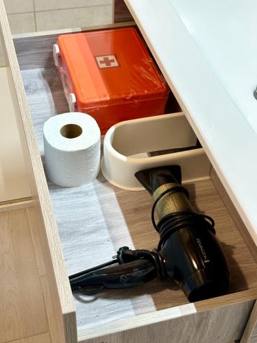 a drawer with a bottle of wine and a roll of toilet paper at Approdo Apartments in Isola Rossa