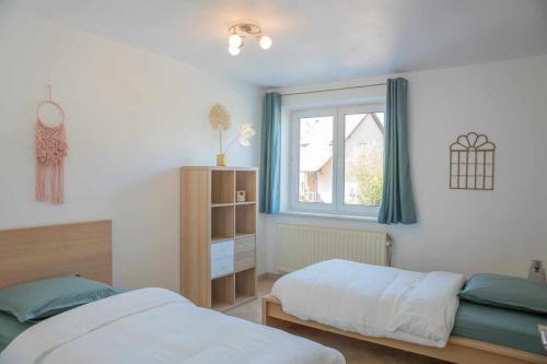 une chambre avec deux lits et une fenêtre dans l'établissement Le Cocon de l'Île, à Dalhunden