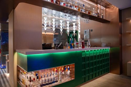 a bar in a restaurant with alcohol bottles at Kainuo Garden Aesthetic Design Hotel Beijing Road - Shisanhang - Railway Station Metro Station - International Trade Center, Yuexiu District Guangzhou-- Reputation Preferred in Guangzhou
