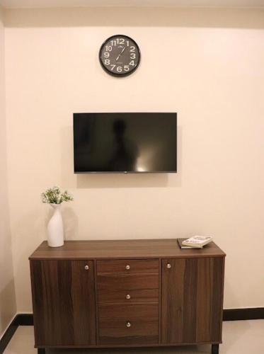 a clock on a wall above a wooden dresser at RK Maisson Roiyale Aurora Escalades Cubao in Manila