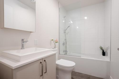 a bathroom with a sink and a toilet and a shower at Stylish 1BDR Apartment in the Heart of DT MTL in Montréal