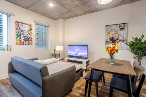 a living room with a couch and a table with a television at Stylish 1BDR Apartment in the Heart of DT MTL in Montréal