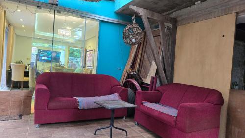 a living room with two red couches and a table at Ña Lucy in Fernando de la Mora
