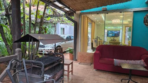 a living room with a red couch and a chair at Ña Lucy in Fernando de la Mora