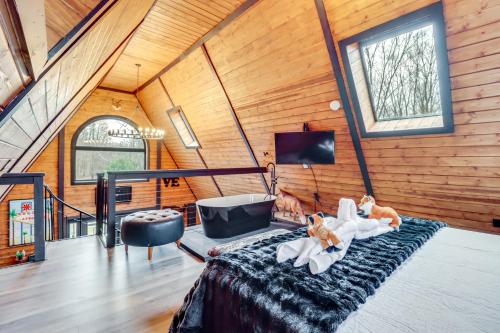 a room with a bed and a tv and windows at Hot Tub and Fire Pits Albrightsville A-Frame Cabin in Albrightsville