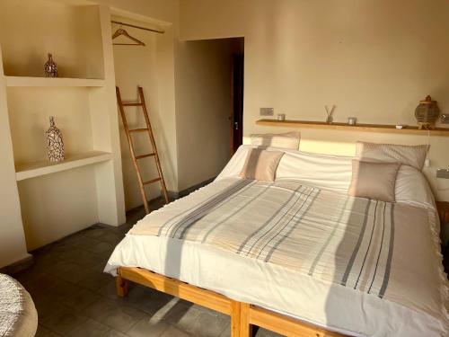 a bedroom with a large bed with a wooden ladder at Villa'S in Zaouiet Bouzarktoune