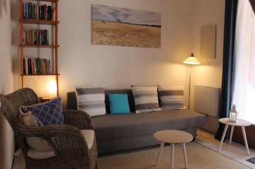 un salon avec un canapé et une chaise dans l'établissement Gruissan Ayguades joli maisonnette 2 personnes, wifi gratuit, à Gruissan