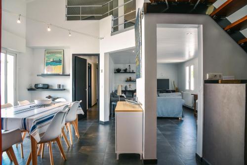 une cuisine et un salon avec une table et des chaises dans l'établissement Villa contemporaine proximité plage et centre, à Capbreton