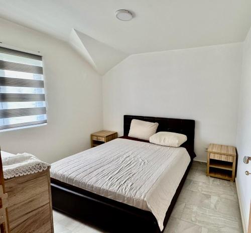a bedroom with a bed and two night stands at Valentina Apartman in Radanovići