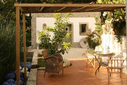 a patio with a table and chairs under a pergola at Casa Burra in Colares