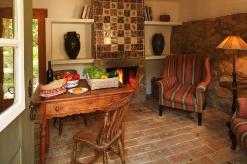 a room with a table and a chair and a fireplace at Casa Burra in Colares