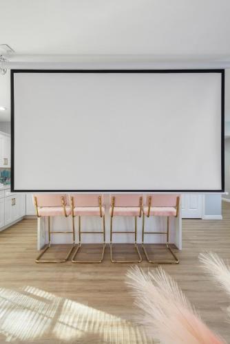 a room with two pink benches and a large screen at Chic pool home 6 mi to beach sleeps 8 in Long Beach