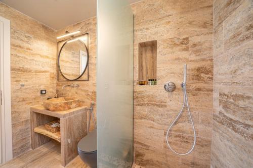 a bathroom with a shower and a toilet and a sink at Irena Stone Villas Kefalonia in Lourdhata