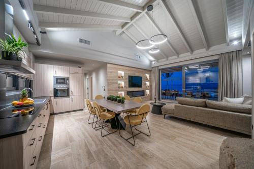 a kitchen and living room with a table and chairs at Irena Stone Villas Kefalonia in Lourdhata