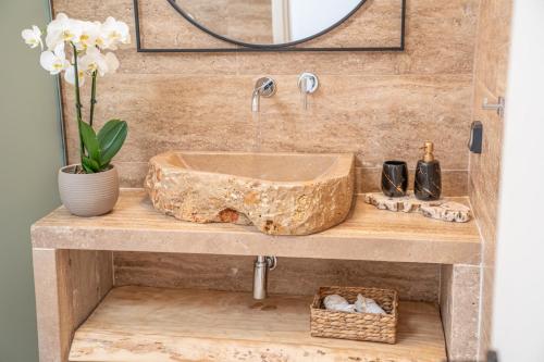 a bathroom with a wooden sink and a mirror at Irena Stone Villas Kefalonia in Lourdhata