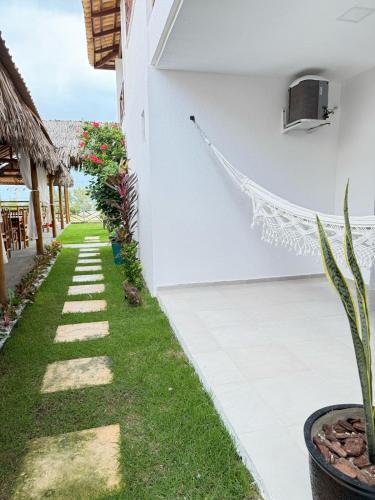a garden outside a villa with a hammock at Milano Hotel Pousada Canoa Quebrada in Canoa Quebrada