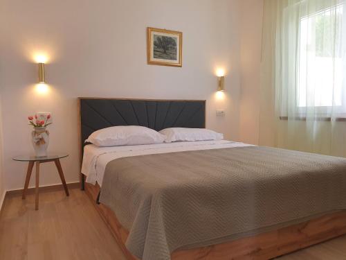 a bedroom with a large bed with a vase of flowers at Apartment D&D in Prigradica