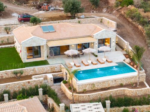 an aerial view of a house with a swimming pool at Irena Stone Villas Kefalonia in Lourdhata