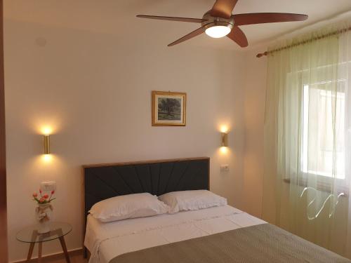 a bedroom with a bed with a ceiling fan at Apartment D&D in Prigradica