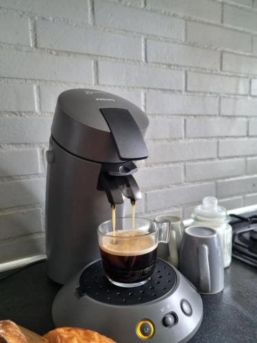 a coffee maker is making a cup of coffee at Grand 2 pièces à 15 min de Paris & Orly Aéroport in Antony