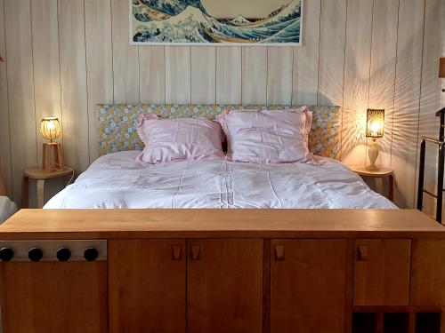 un grand lit dans une chambre avec deux lampes dans l'établissement appartement de plain-pied tout confort, à Carla-Bayle