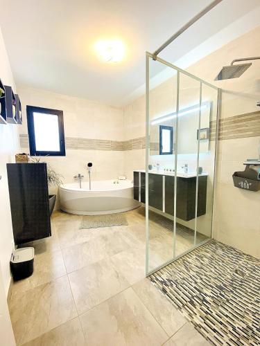 une salle de bain avec une douche en verre et une baignoire dans l'établissement Villa Classée 3 étoiles familiale calme et nature, à Étaules