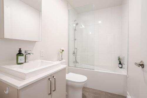 a bathroom with a sink and a toilet and a shower at Modern 1BR in downtown in Montréal