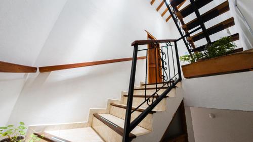 a staircase in a house with wooden railings at ApartaHotel Margaritas de la Villa VDL in Villa de Leyva