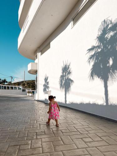 a little girl standing in front of a building at CAPTAIN'S RESIDENCE in Ksamil