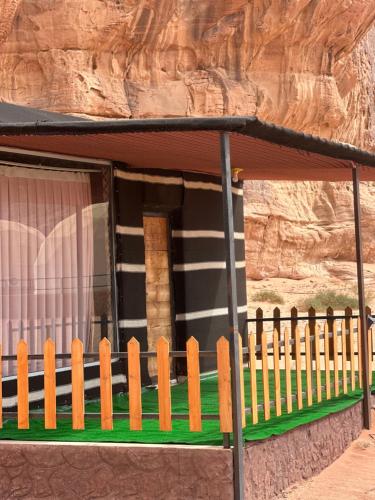 a house with a fence in front of a mountain at Wadi Rum Grand in Wadi Rum