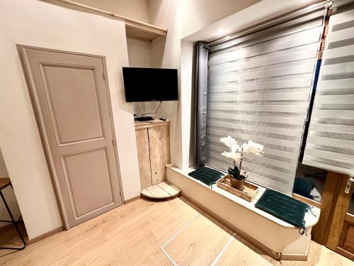 a room with a window with a door and a television at Agréable studio plein centre in Saint-Gaudens
