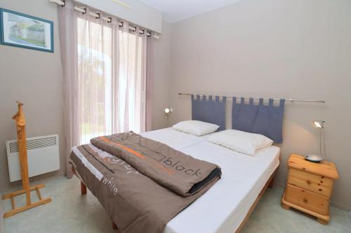 une chambre avec un lit avec une couverture dessus dans l'établissement Le Jardin de La Baule by Tranquil at Home, à La Baule