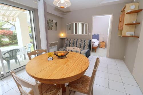 - une salle à manger et un salon avec une table et des chaises en bois dans l'établissement Le Jardin de La Baule by Tranquil at Home, à La Baule