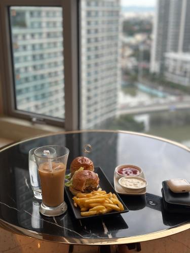 a tray with donuts and fries and a drink on a table at Novotel Suites Celestia at Hotel Residences Manila in Manila