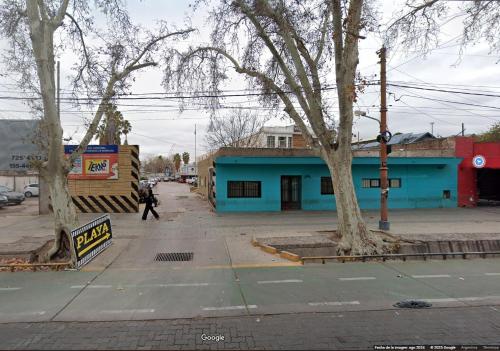 a person walking down a street next to a blue building at Departamento Inigualable en Ciudad de Mendoza in Barraquero