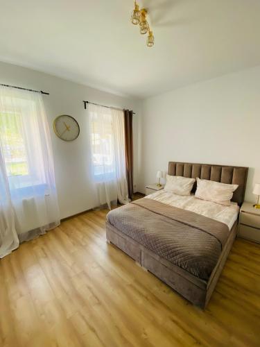 a bedroom with a bed and a clock on the wall at Przytulny apartament z tarasem in Olsztynek