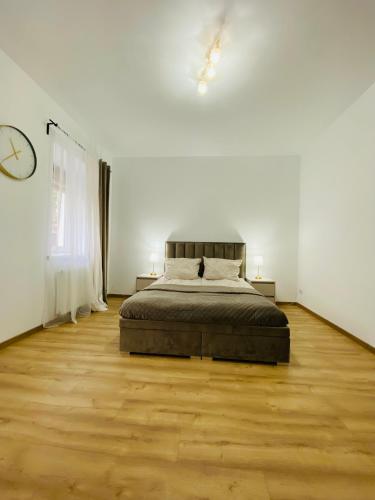a bedroom with a bed and a clock on the wall at Przytulny apartament z tarasem in Olsztynek