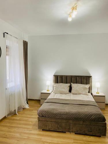 a bedroom with a large bed and two lamps at Przytulny apartament z tarasem in Olsztynek